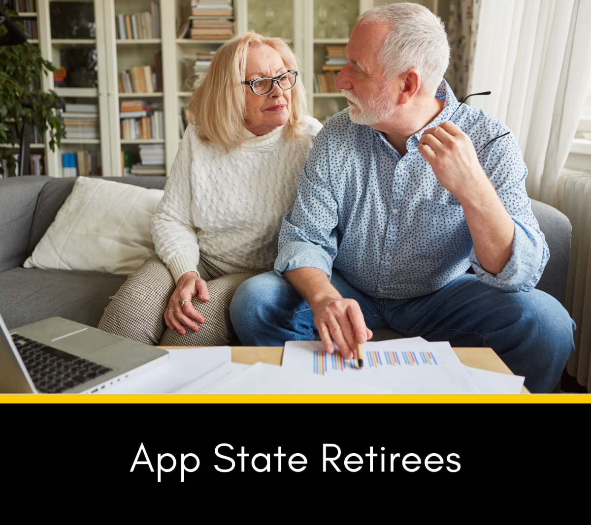 Retired couple sitting on the couch talking with a laptop nearby