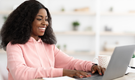 Student smiling while looking at laptop