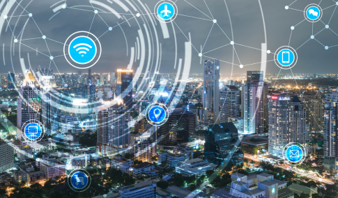 Image of a big city at night with logos of wifi, computer, email, cellphone