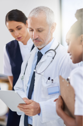 Medical professionals looking over a chart on a handheld device